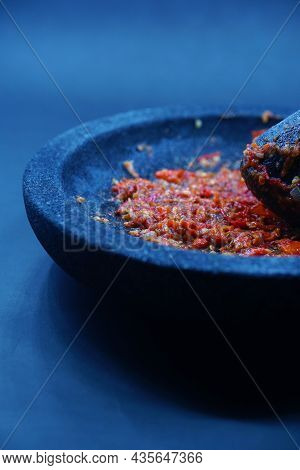 Red Chili Sauce On A Stone Mortar And Pestle. Dark Background, Focus Selected.