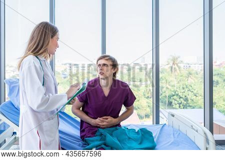 Female Doctor With Hands Of Checking Man Patient Having Has Gotten A Severe Stomach Ache Lying On Be