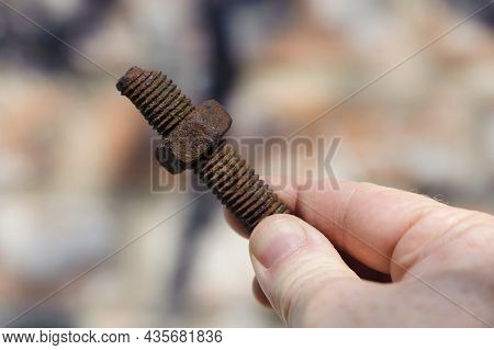 Old Rusty Bolt, Iron Rod With Screw Threads, In Hand. Rusted Mechanical Components. Holding Threaded