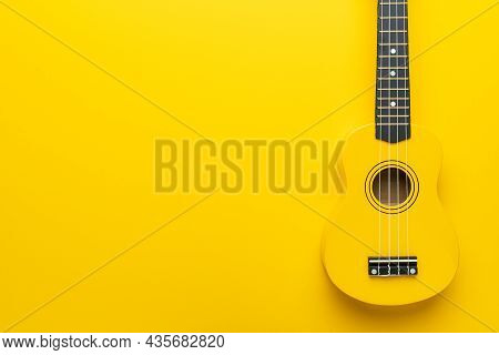 Overhead Photo Of Ukulele With Copy Space. Yellow Colored Wooden Ukulele Guitar. Starter Ukulele On 