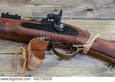 Old Rifle Gun With A Trigger Close-up On A Wooden Table