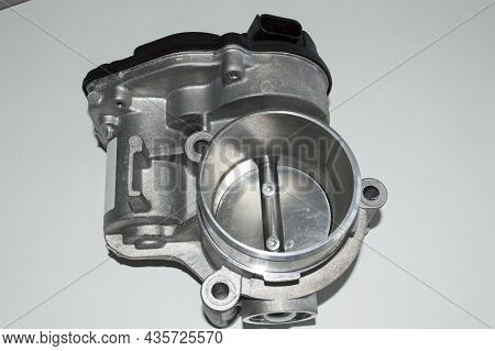 Top View Of The Car Throttle Valve, Which Lies On A White Surface