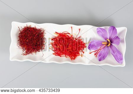 Saffron Spice And Flower With Stamens On A White Saucer. Dry And Undried Spice.