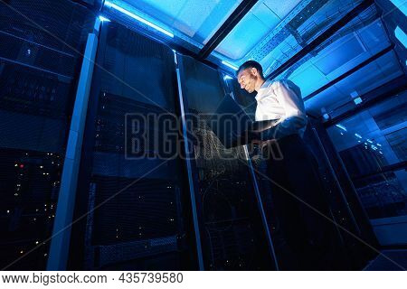 Network Administrator Using Laptop While Doing Computer Equipment Checkup