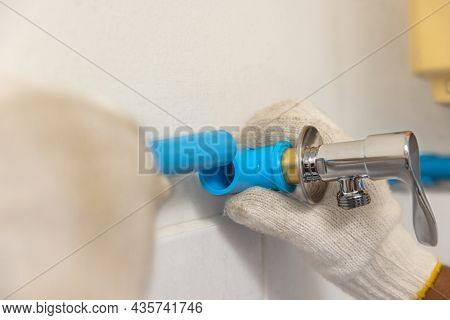 Worker Installing Floating Pipeline On The Wall In The Old Bathroom