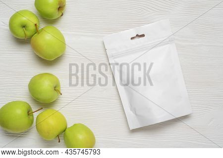 White Plastic Pouch Bag With Apples On Wood Table. Mock-up Template For Design. 3d Rendering Illustr