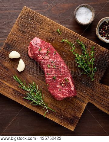 Raw Contre-filet Striploin Steak With Garlic And Rosemary, Thyme, Salt And Pepper On Wooden Board. U