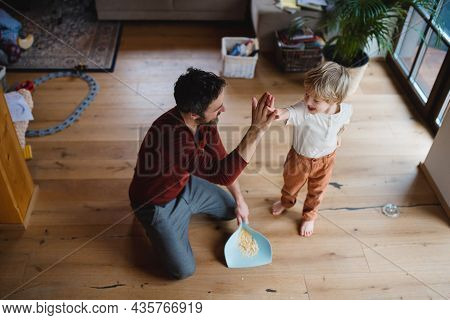 High Anlge View Of Father High Fiving With Small Son After Sweeping At Home, Daily Chores Concept.