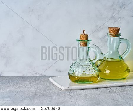 Set Of Extra-virgin Olive Oil Glass Bottles On White Texture Background. Golden Healthy Mediterranea