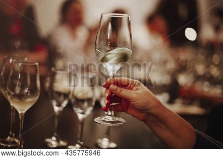 Glasses With Different Types Of Wine And Human Hands Holding Wine Glasses In The Background. Degusta