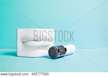 White Metalic Microphone With Stone Lips Podium On Light Blue Background. Interview And Podcast Conc