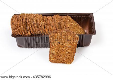 Small Thin Brown Rusks With Different Seeds In Plastic Packaging And One Rusk Separately On A White 