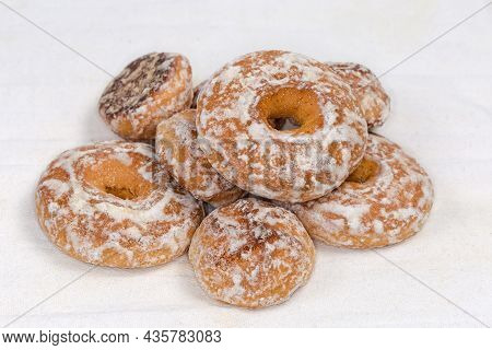 Round And Ring Shaped Spice Cookies Glazed With Icing Sugar On The White Fabric Napkin, Close-up In 