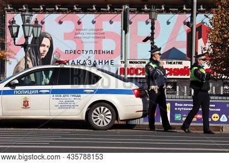 Moscow, Russia - October 2021: Two Traffic Police Officers In Masks Standing On The Road Near Their 