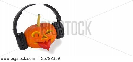 Halloween Pumpkin With Headphones For Music On White Background. Tongue Out Of Pepper. Jack Lantern 