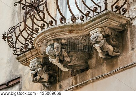 Beautiful baroque mascaron ornament of a balcony in the old town of Ragusa, Sicily, Italy