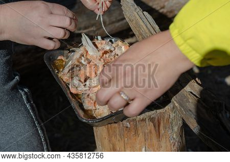 Two Women Are Going Over Pieces Of Cooked Fish With Their Hands. They Are Removing The Fish Bones. S