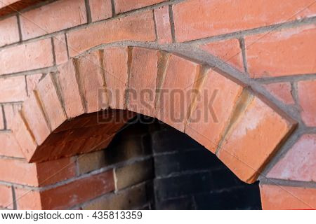 Fireplace New Built Of Red Brick With Arched Firebox Close-up Heating The House