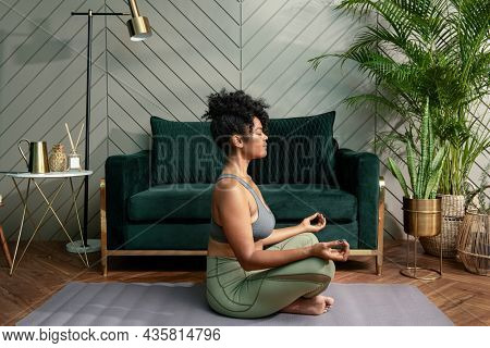 Healthy woman meditating in the living room