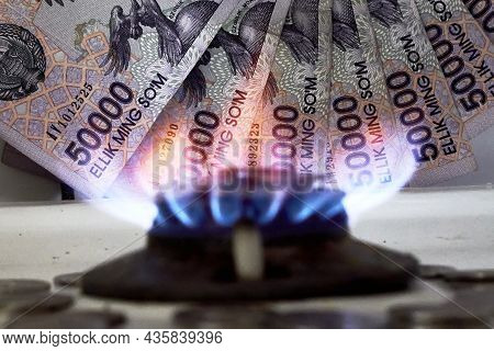 Burning Gas Stove Burner And Uzbek Money - Sum Banknotes. Pay For Natural Gas, Bill, Tariff. Growing