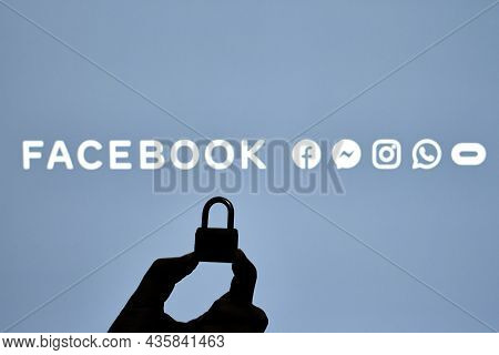 Tashkent, Uzbekistan - 7 October 2021: Silhouette Of A Person Hand Holding A Padlock Over Facebook L