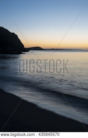 Beautiful Sunrise Over Pentewan Sands In Cornwall With Pastel Sky And Long Exposure Ocean