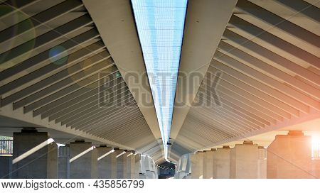 Sunlight Penetrates Under Overpass. Highway Overpass Bridge Concrete Structure With Columns.