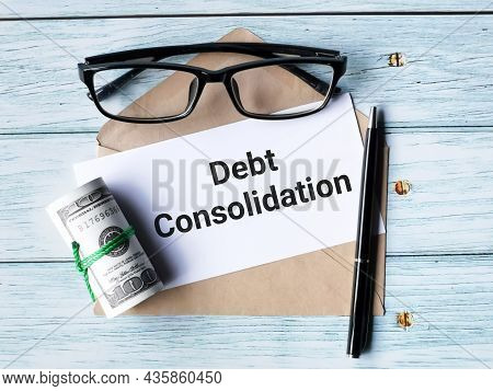 Finance Concept. Text Debt Consolidation Written On White Paper With A Pen,brown Envelope,fake Money