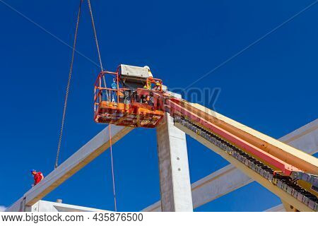 Mobile Crane Is Operating And Worker Is Assembly Concrete Joist In High Place. Height Worker Is Plac