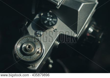 Soviet Film Camera Zenit-e With Industar 50-2 Lens. Tilted Composition, Close-up, Black Background