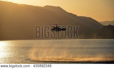 Russian KA-32 helicopter draws water from the sea to extinguish a forest fire. 30 July, 2021. Marmaris,Turkey