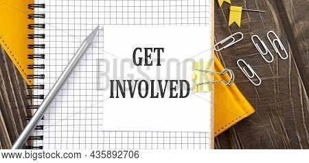 Get Involved Text On Sticker On Notebook, Wooden Background