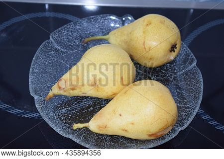Three Very Ripe Pears On A Glass Plate