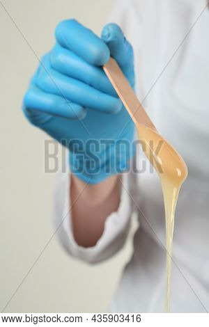 Woman In Gloves Holding Spatula With Hot Depilatory Wax, Closeup
