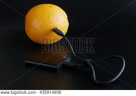 The External Ssd Is Wired To A Fresh Orange. Data Transfer And Storage Concept. Green Technology Con