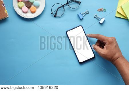 Top View Of Man Hand Using Smart Phone On Office Desk