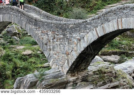Lavertezzo, Switzerland: People Enjoy The Magnificent Double-arched Stone Bridge Ponte Dei Salti On 