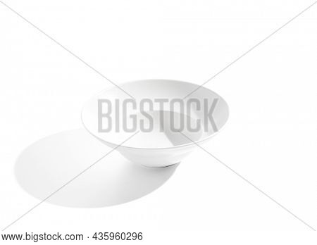 Empty white plate isolated on white background. Modern white ceramic with hard shadow. Empty tableware. White bowl in minimal style