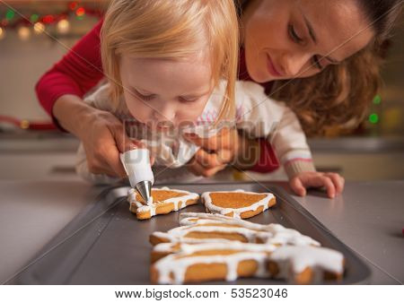 Baby Helping Mother Decorate Homemade Christmas Cookies With Glaze