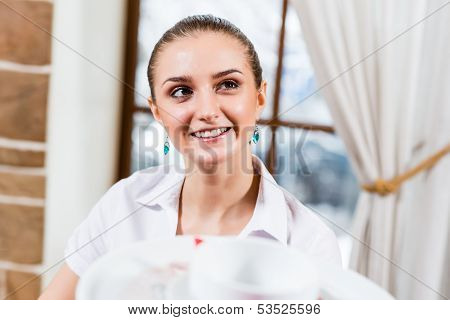 waiter brings a dish for a nice woman