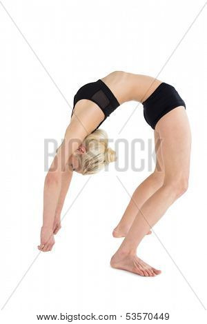 Full length side view of a fit young woman bending backwards over white background