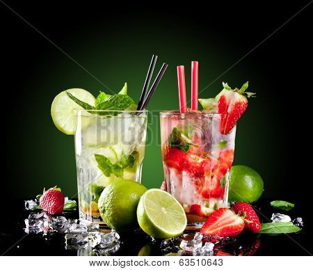 Studio shot of fresh mojito drinks with slime slices, isolated on black background