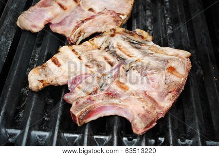 Close-up Of A Juicy Porkchop Cooking On A Grill