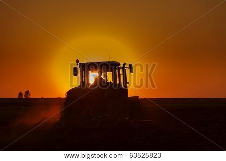 Tractor plowing in dust