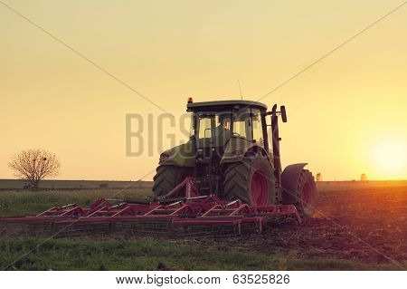 Tractor plowing in dust