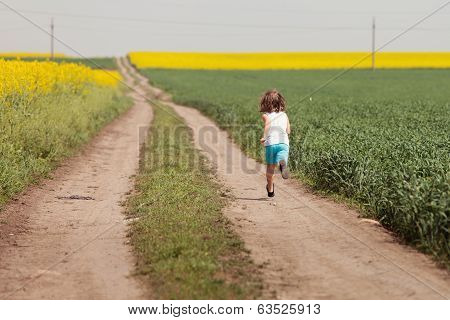 Happy girl running on a rural road