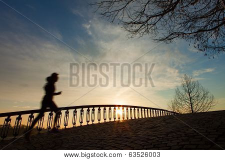 Silhouette Of The Running Girl At Sunrise On The Bridge