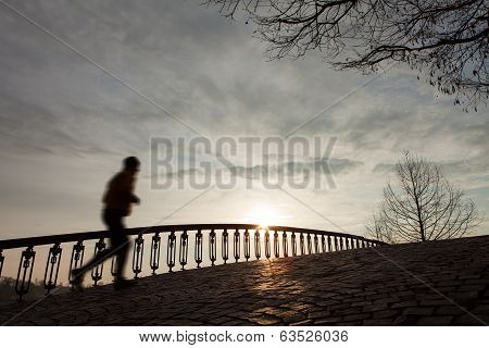 Silhouette Of The Running Man At Sunrise On The Bridge