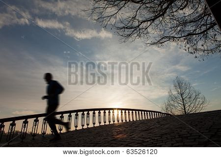 Silhouette Of The Running Man At Sunrise On The Bridge