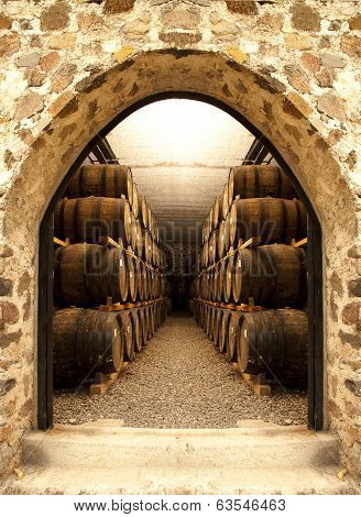 Wine barrels stacked in the old cellar of the winery.